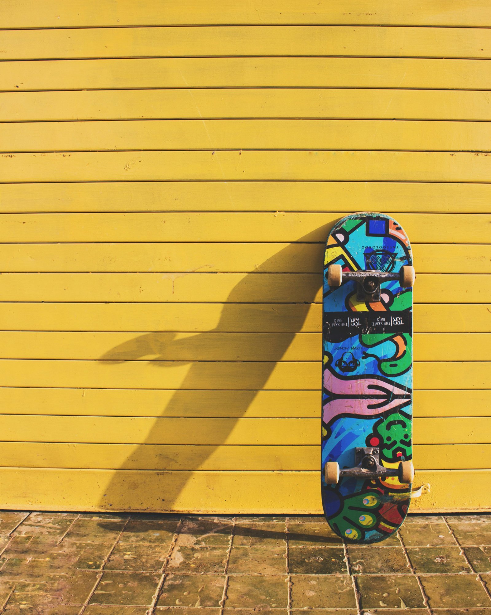 Skateboard against yellow wall — Cooler House attitude
